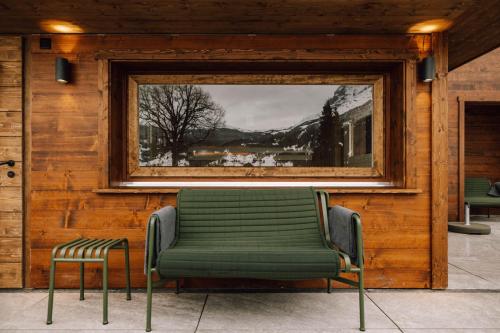 a green bench in a room with a window at Hotel Fiescherblick in Grindelwald