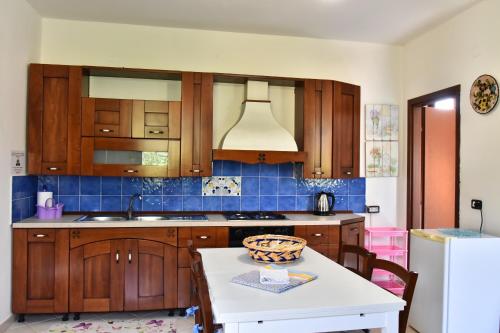 una cocina con armarios de madera y una mesa blanca en Country House Felicia, en Giungano