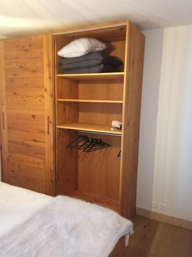 a wooden cabinet in a room with a bed at Agréable appartement à Grimentz, au pied des pistes in Grimentz