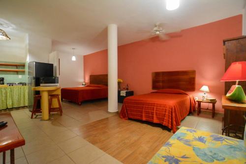 ein Hotelzimmer mit 2 Betten und roten Wänden in der Unterkunft Bungalows Teka in Zihuatanejo