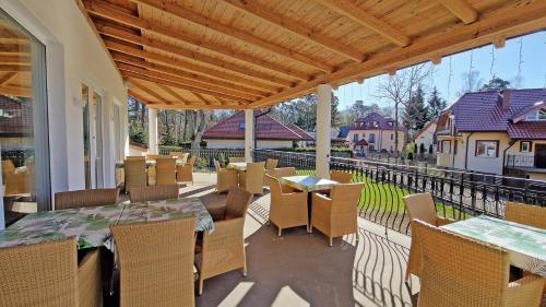 a patio with tables and chairs on a balcony at Doliva Park in Krynica Morska