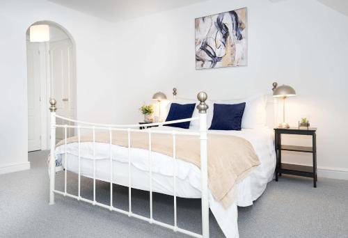 a bedroom with a white bed with blue pillows at Entire House in Ipswich in Ipswich