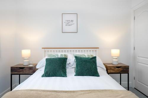 1 dormitorio con cama blanca y almohadas verdes en Entire House in Ipswich, en Ipswich