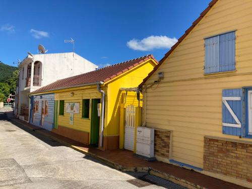 a row of colorful buildings on a street at Caraïbe in Les Anses-dʼArlets
