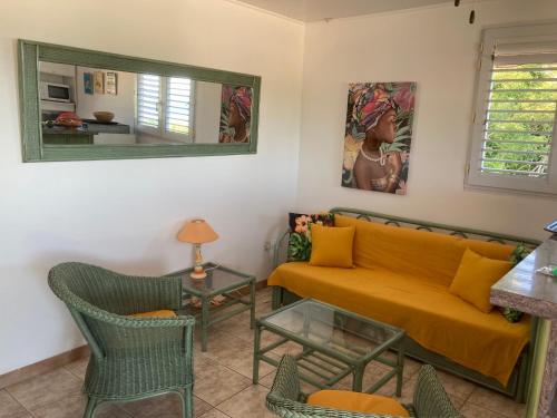 a living room with a couch and a table at Caraïbe in Les Anses-dʼArlets