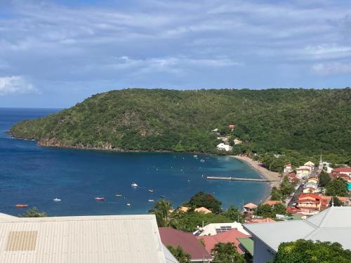 a view of a town and a body of water at Caraïbe in Les Anses-dʼArlets