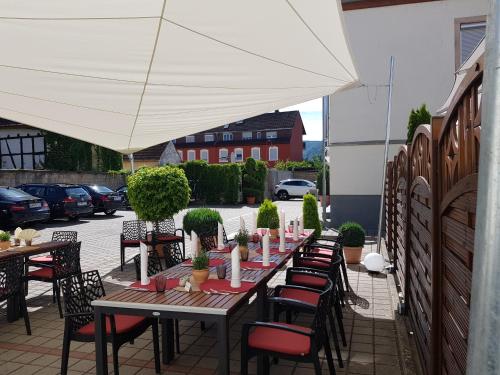 a table with chairs and an umbrella on a patio at Hotel-Restaurant Pfälzer Hof in Edenkoben