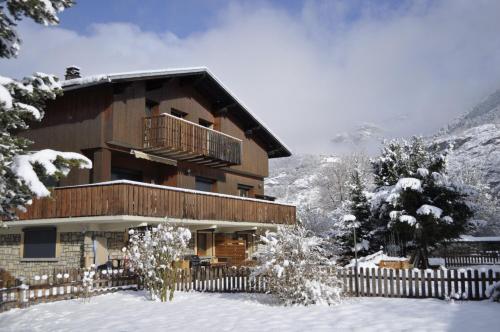 ル・ブール・ドアザンにあるChalet la Cachette Cyclists & Skiersの雪の中のバルコニー付きの建物