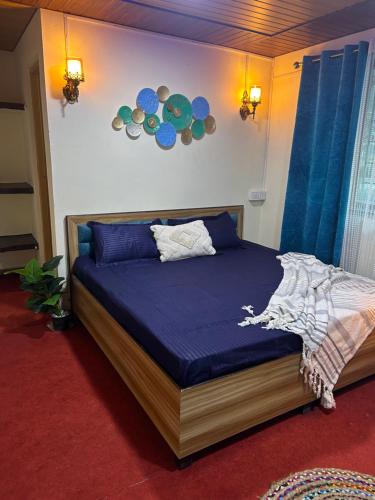 a bedroom with a bed with a blue comforter at Laxmi Narayan Homestay-Harshil in Harsil