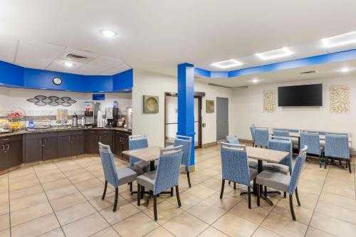 a dining room with tables and chairs and a kitchen at Best Western St. Louis Inn in Arnold