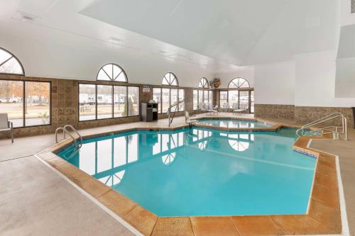 a large pool with blue water in a building with windows at Best Western St. Louis Inn in Arnold