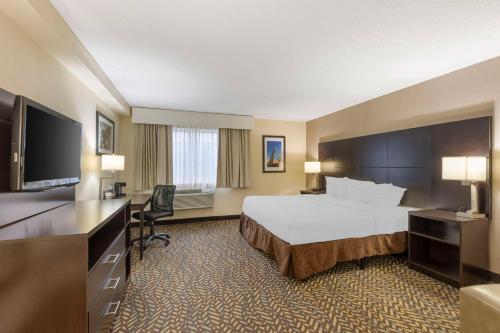 a hotel room with a bed and a flat screen tv at Best Western St. Louis Inn in Arnold