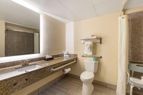 a bathroom with a toilet and a sink and a mirror at Best Western St. Louis Inn in Arnold