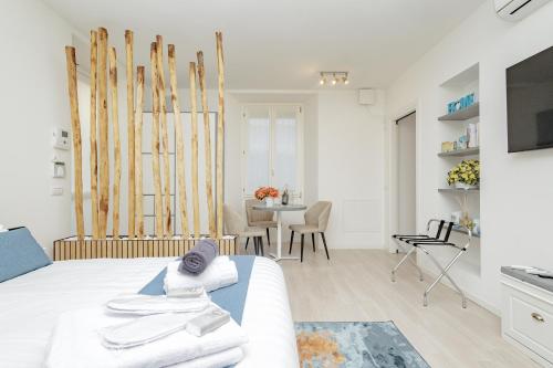 a white room with a bed and a dining room at 2 passi dal lago, Como Lake in Abbadia Lariana