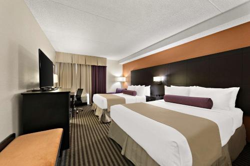 Cette chambre comprend deux lits et une télévision. dans l'établissement Best Western Plus Toronto North York Hotel & Suites, à Toronto