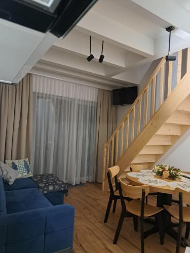 a living room with a blue couch and a table at SOLEK Apartamenty i pokoje gościnne in Mielno