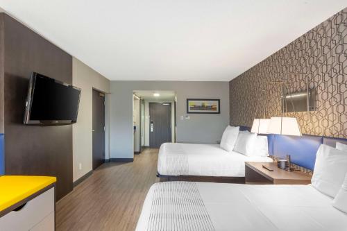 a hotel room with a bed and a flat screen tv at GLō Best Western Mississauga Corporate Centre in Mississauga