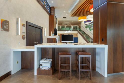 a kitchen with a bar with two stools and a desk at GLō Best Western Mississauga Corporate Centre in Mississauga