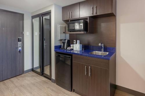 a kitchen with a sink and a counter top at GLō Best Western Mississauga Corporate Centre in Mississauga