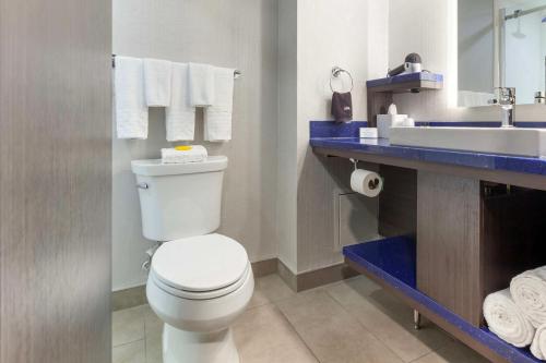 a bathroom with a white toilet and a sink at GLō Best Western Mississauga Corporate Centre in Mississauga