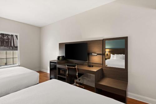 a hotel room with a desk with a tv and a bed at Best Western Shackleford in Little Rock