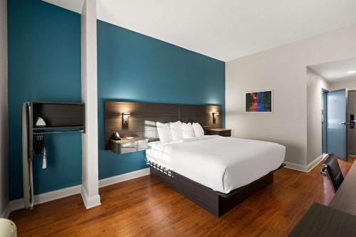 a bedroom with a large bed with a blue wall at Best Western Shackleford in Little Rock