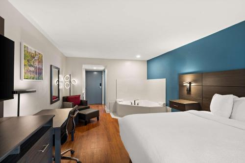 a hotel room with a bed and a bath tub at Best Western Shackleford in Little Rock