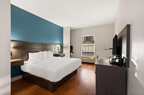 小石城的住宿－華美小石城酒店，配有一张床和一台平面电视的酒店客房