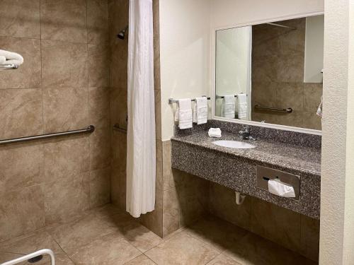 a bathroom with a sink and a mirror at Motel 6 Galveston, TX Seawall in Galveston
