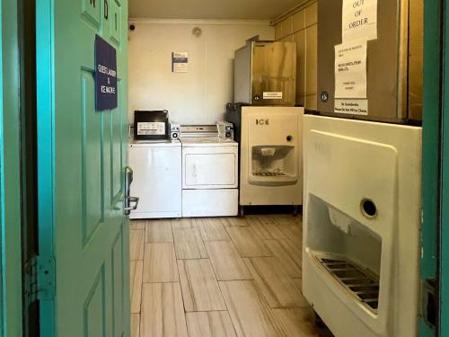a kitchen with white appliances and an open door at Motel 6 Galveston, TX Seawall in Galveston