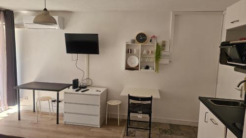 - une cuisine avec un bureau, une table et des chaises dans l'établissement Quatro Venusia, à Sète