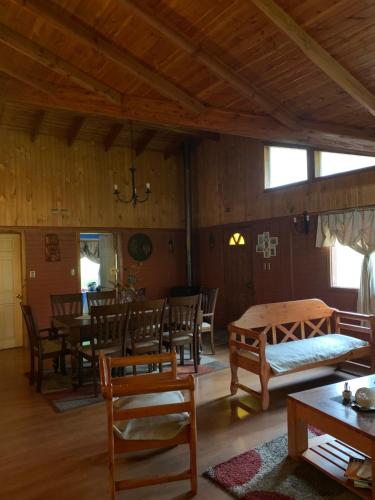 una sala de estar con mesas y sillas y un comedor. en Casa de Campo, en Temuco