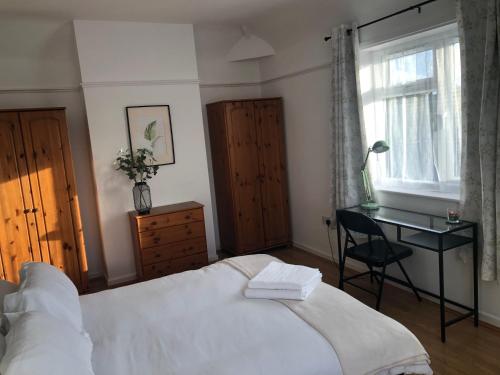 a bedroom with a bed and a desk and a window at Butterfly Home in London