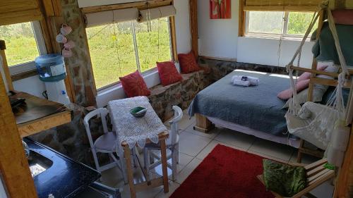 um quarto com uma cama, uma mesa e cadeiras em Cabaña en el campo em Tacuarembó