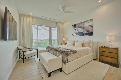 a bedroom with a bed and a chair and a window at ONE Canal Point in Upper Land