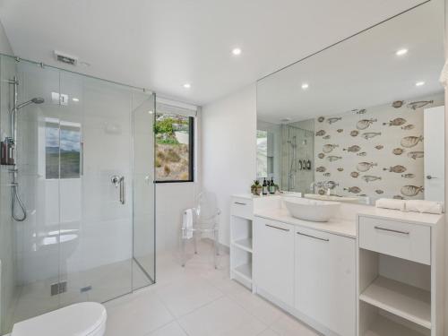a bathroom with a shower and a toilet and a sink at Hawthorne House in Queenstown