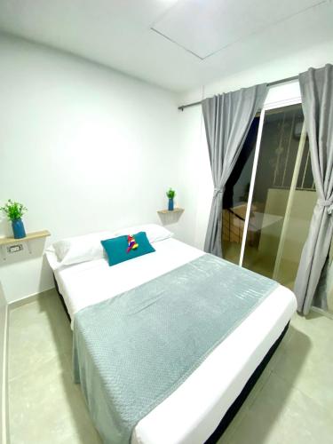 um quarto com uma cama com uma almofada azul em Guakmaya hostel em Cartagena de Indias