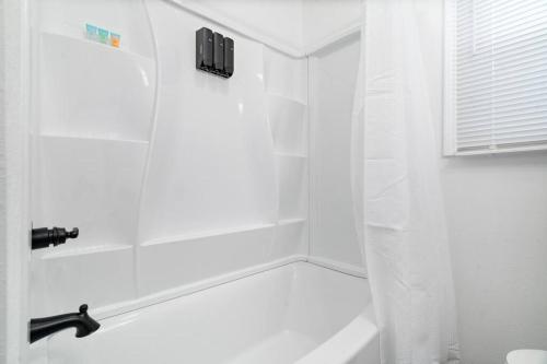 a white bathroom with a tub and a shower at Urban Oasis centrally located near downtown! in Evansville