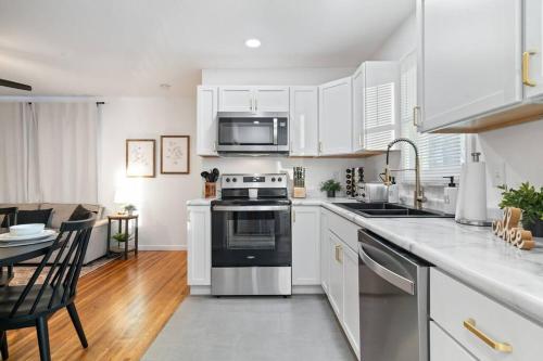 a kitchen with white cabinets and a stove top oven at Urban Oasis Cozy Home Near Downtown with Game Room and Firepit in Evansville