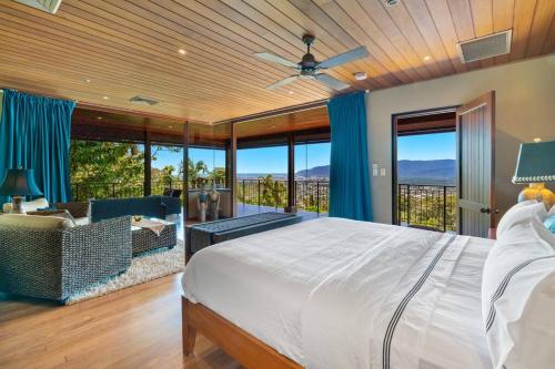 a bedroom with a bed and a couch and windows at Barong Luxury Home overlooking Cairns Unrivalled privacy and location in Cairns