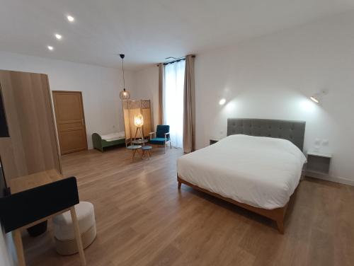 a bedroom with a white bed and a room with a table at Clos de la Providence Chambres d'hôtes, piscine et Spa in Nolay