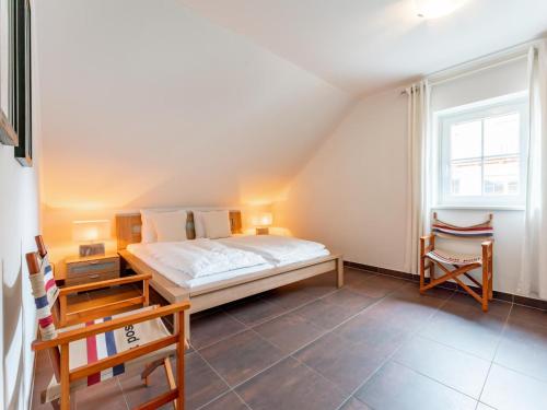 ein Schlafzimmer mit einem Bett und zwei Stühlen darin in der Unterkunft Schneeweiss in Mauterndorf