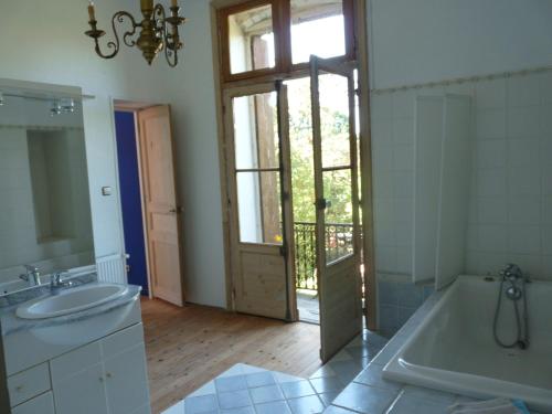 a bathroom with a tub and a sink and a mirror at Chateau la Bouriette in Moussoulens