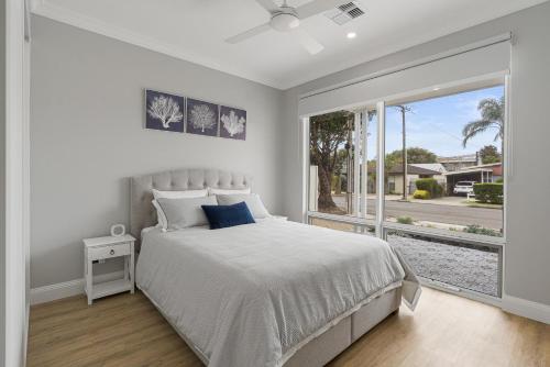 - une chambre blanche avec un lit et une grande fenêtre dans l'établissement 35 Newland St Victor Harbor, à Victor Harbor
