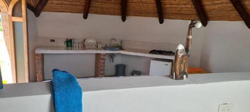 a kitchen with a counter top with a blue pillow at Maloka lago de bachue in Villa de Leyva