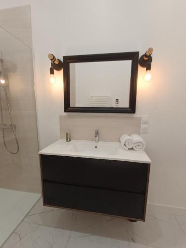 a bathroom with a sink and a mirror at Clos de la Providence Chambres d'hôtes, piscine et Spa in Nolay