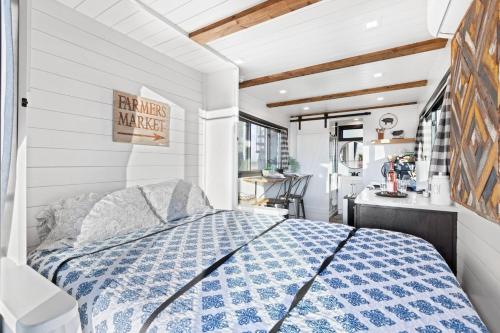 1 dormitorio con 1 cama con edredón azul y blanco en Tiny Cargo Home North, en Tulare