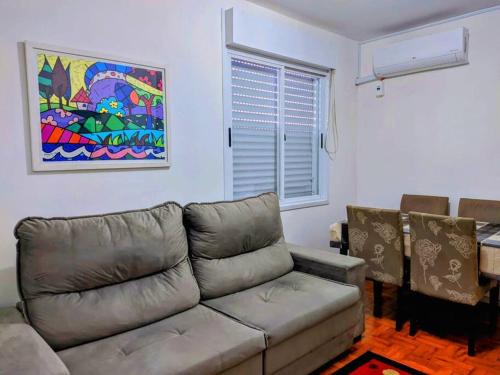 uma sala de estar com um sofá e uma pintura na parede em Charmoso apartamento próximo ao Consulado EUA em Porto Alegre