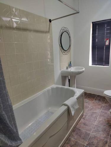 a bathroom with a bath tub and a sink at 1 bedroom flat in Neepsend