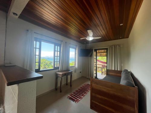 Cette chambre comprend un canapé, une table et des fenêtres. dans l'établissement BEAUTIFUL VIEW, à Angra dos Reis